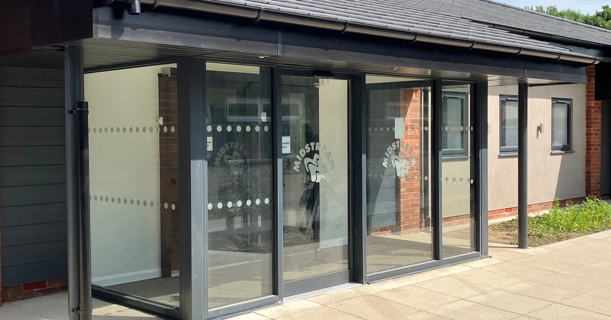 Commercial aluminium entrance doors installed on a building exterior with glass panels and dark frames