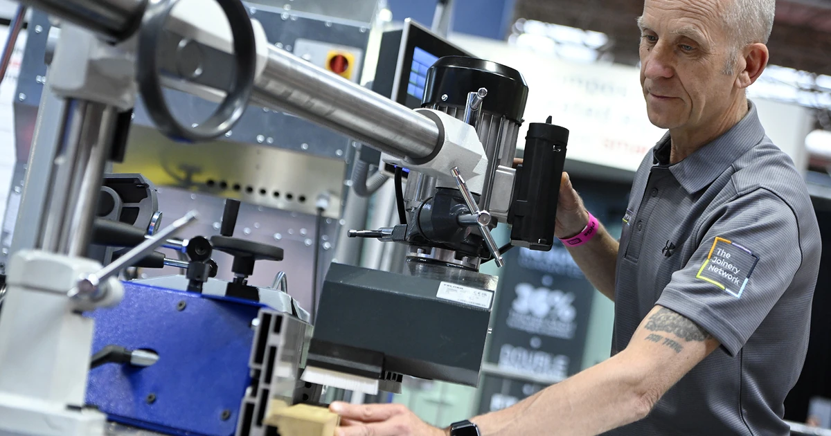 Man in a shirt with The Joinery Network logo operating timber joinery machinery