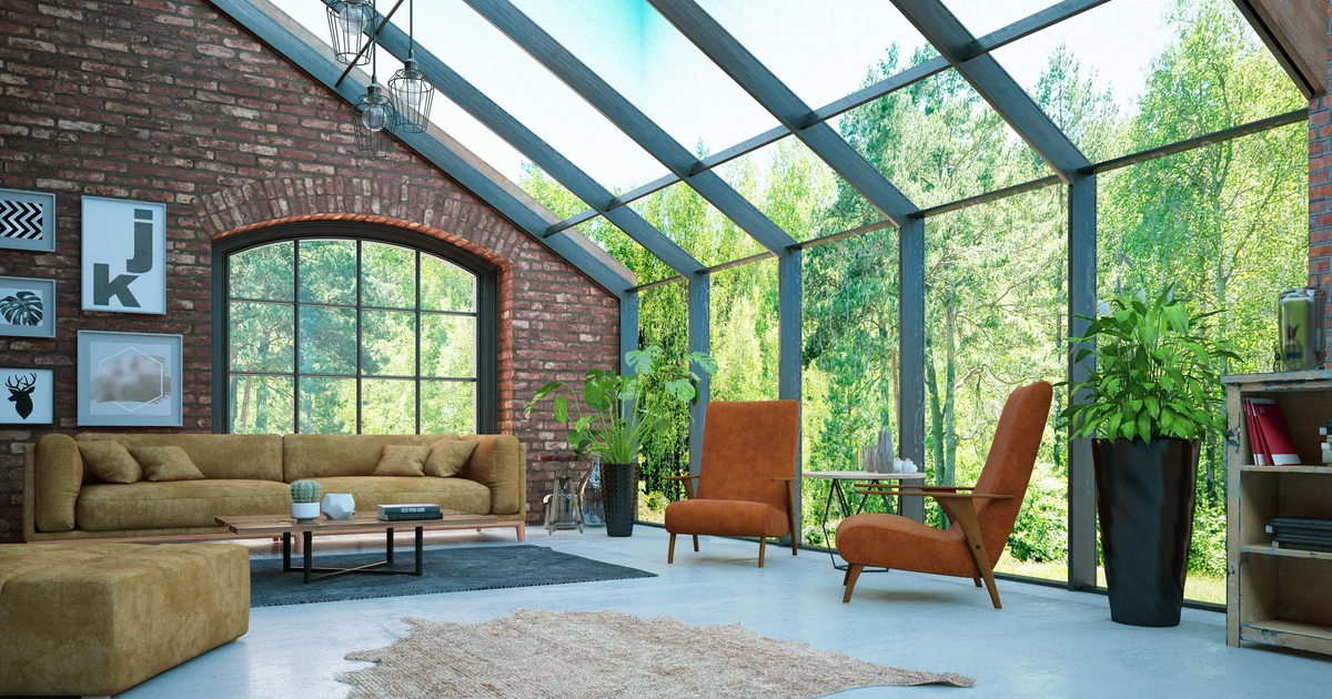 Modern living room with large glass roof and walls, abundant natural daylight and view of trees outside
