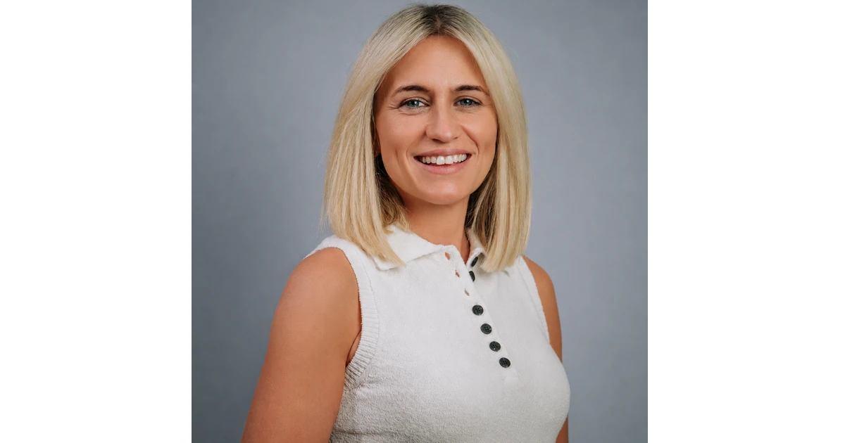 Lauren Mawford smiling in a sleeveless white top against a plain gray background
