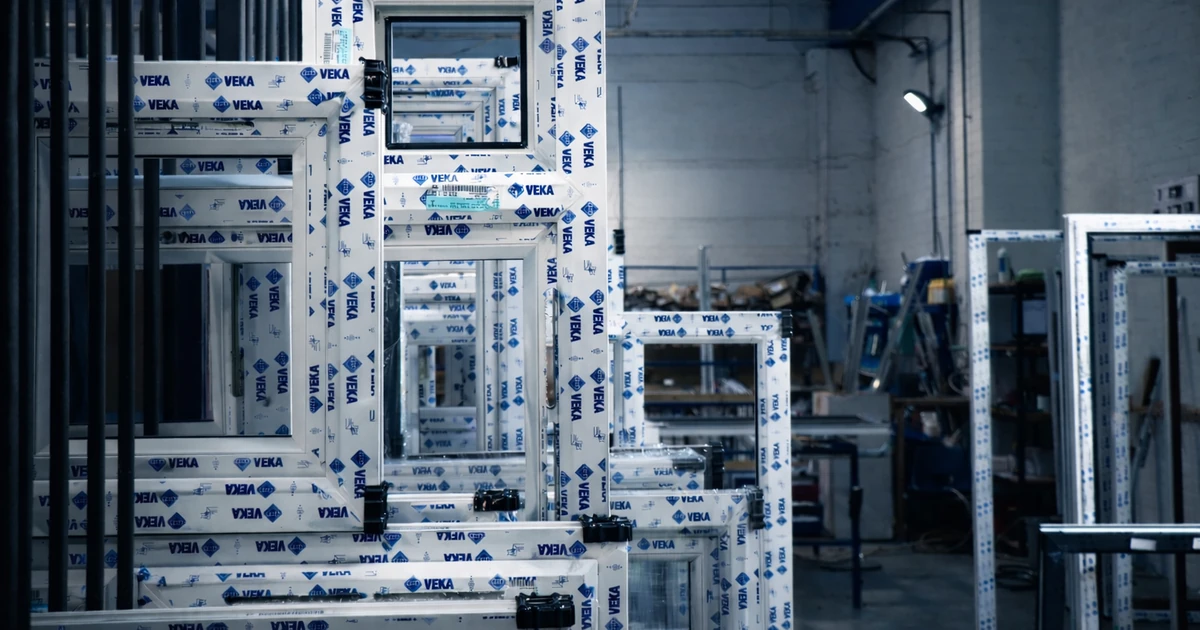 Stacked VEKA-branded window and door frames in a manufacturing setting